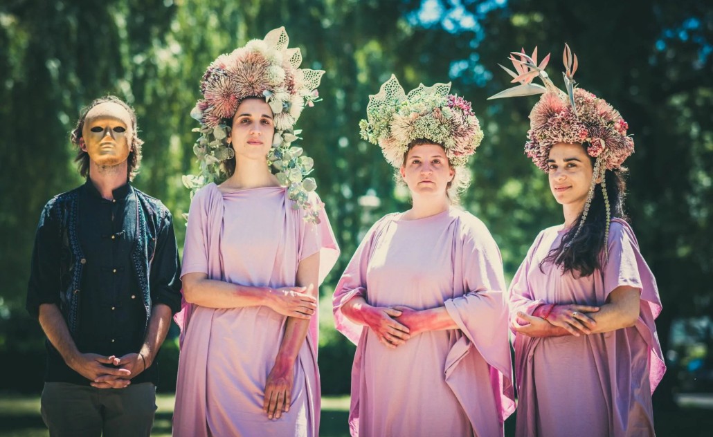 Mak Murtić s maskom i pjevačice Mimika orkestra u ružižastim haljinama s cvijećem na glavi